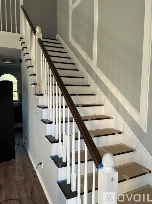 A staircase with white railings and a wooden handrail.