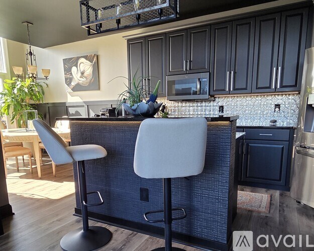 A kitchen with a blue backsplash and a white chair.