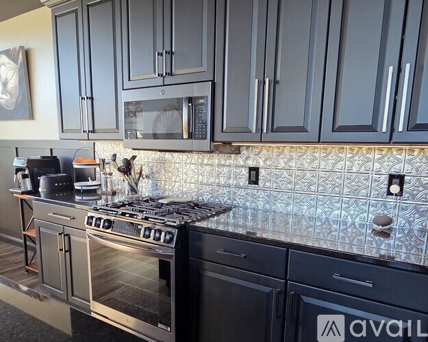 A kitchen with a stove top oven and a microwave above it.