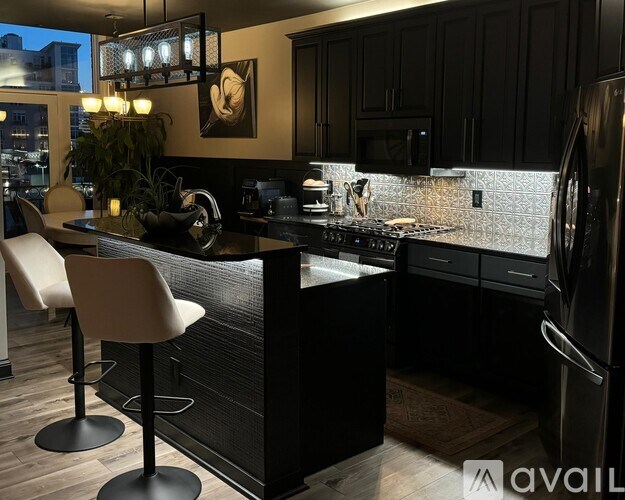 A modern kitchen with black cabinets and a large island.