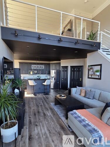 A living room with a couch, a coffee table, and a potted plant.