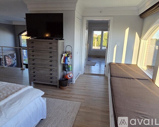 A bedroom with a large bed and a dresser with a flat screen TV on top.