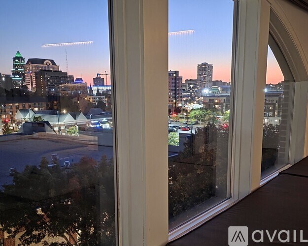 A view of a cityscape from a window at dusk.
