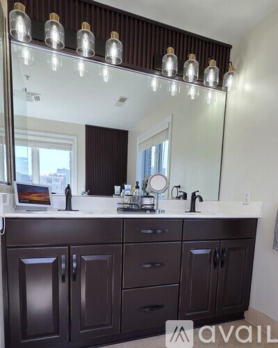 A bathroom vanity with a mirror and lights above it.