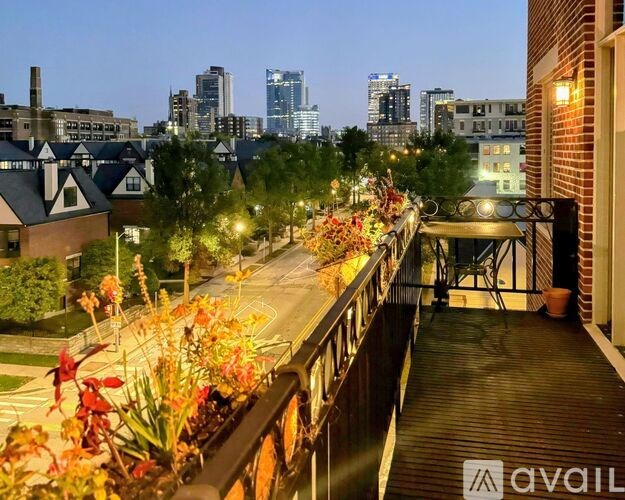 A balcony with flowers and a city skyline in the background.