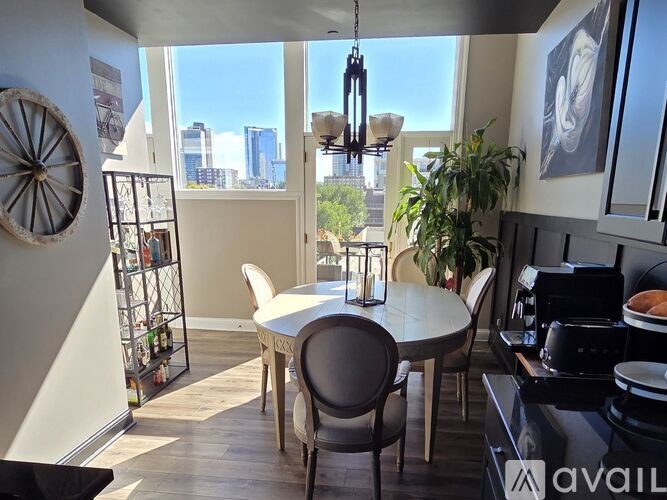 A kitchen with a table and chairs and a view of the city.