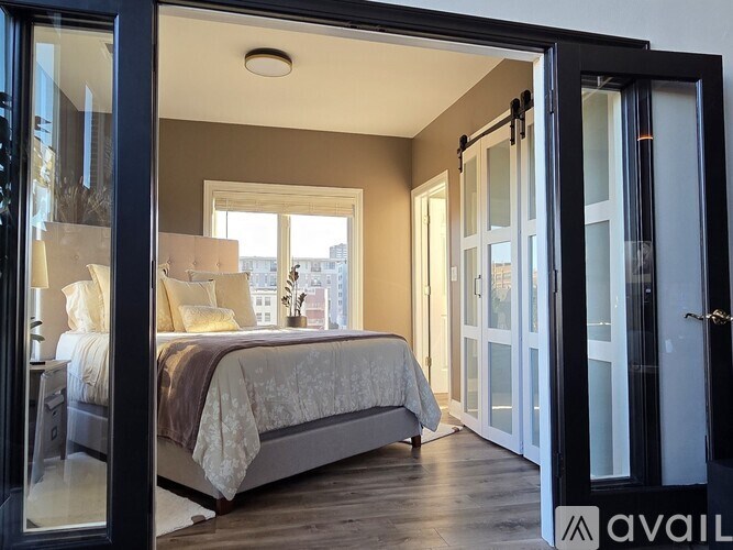 A bedroom with a bed and a view of the city through the window.
