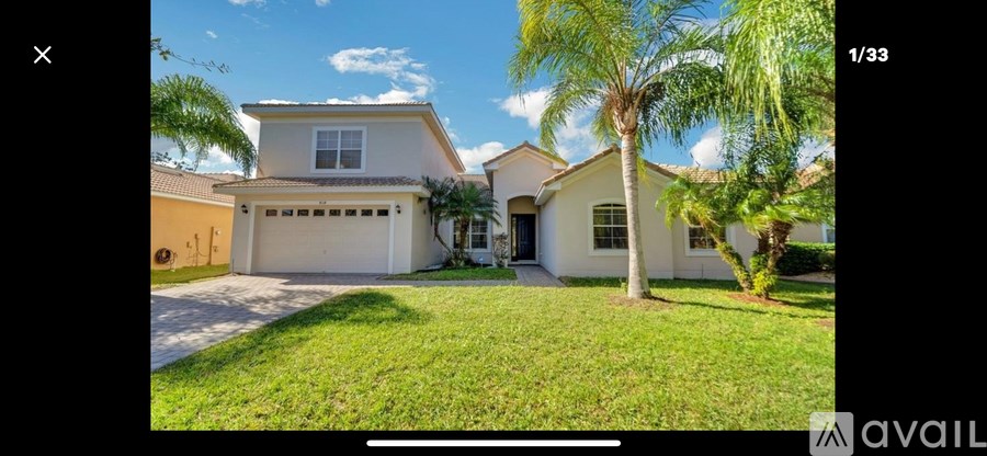 A house with a garage and a tree in front.