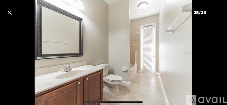 A bathroom with a toilet, sink, and mirror.