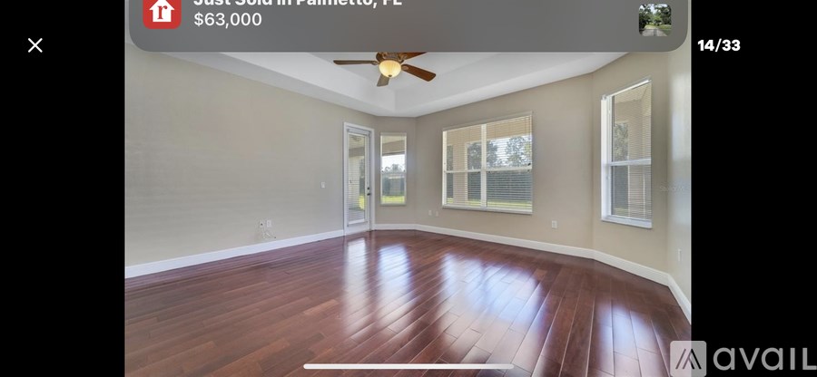 A room with wooden flooring and a ceiling fan.