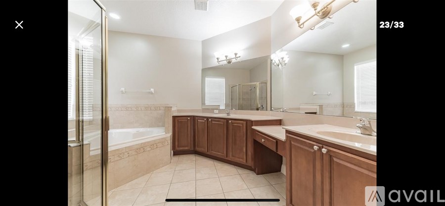 A large bathroom with a tub, sink, and mirror.