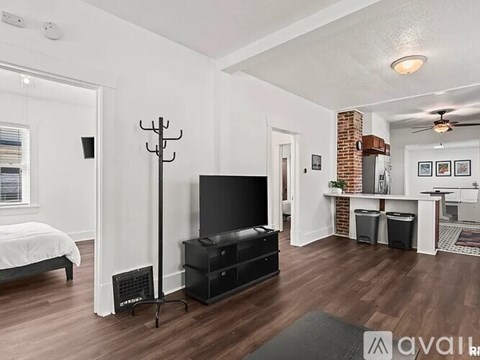 A living room with a television and a stand.