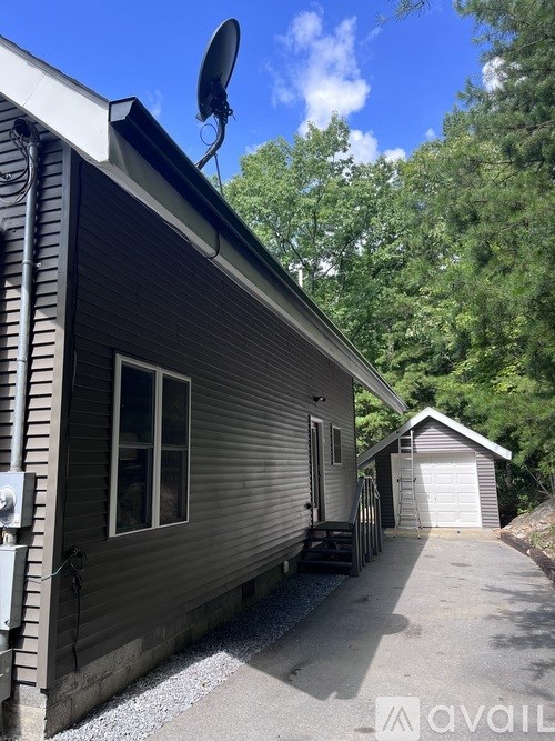 A house with a satellite dish on the roof and a garage door.