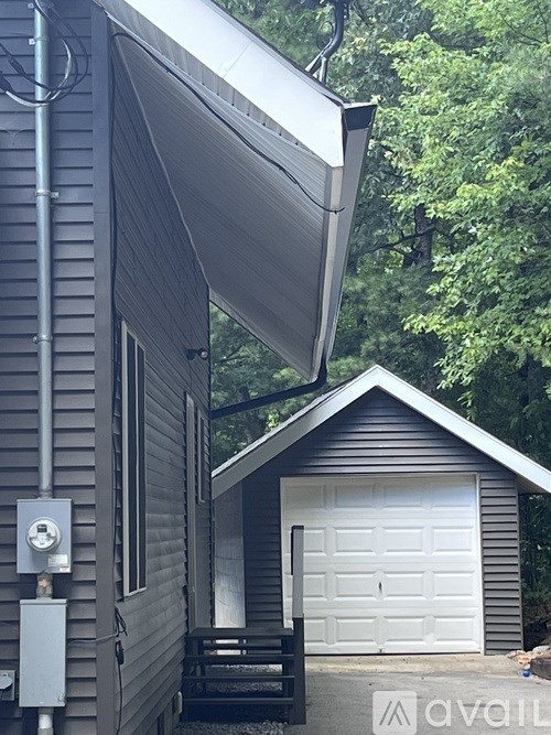 A house with a garage door and a solar panel on the roof.