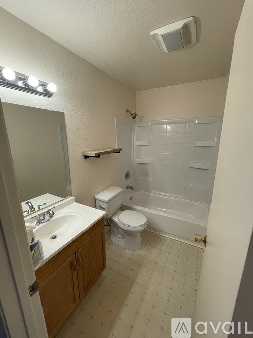 A bathroom with a toilet, sink, and shower.