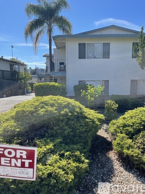 A house with a for sale sign in front of it.