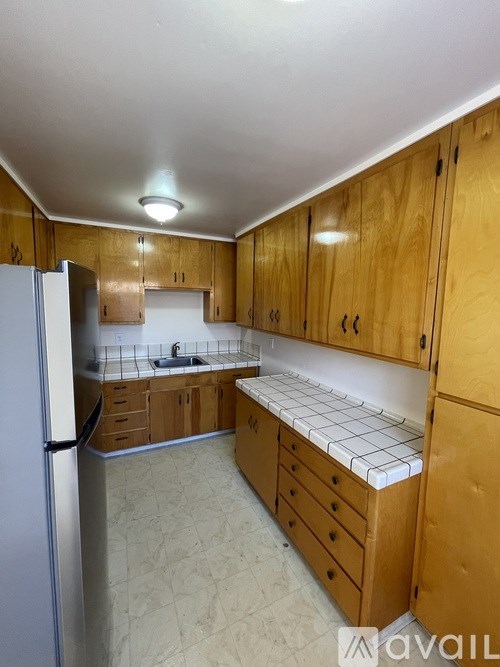 A kitchen with wooden cabinets and a white refrigerator.