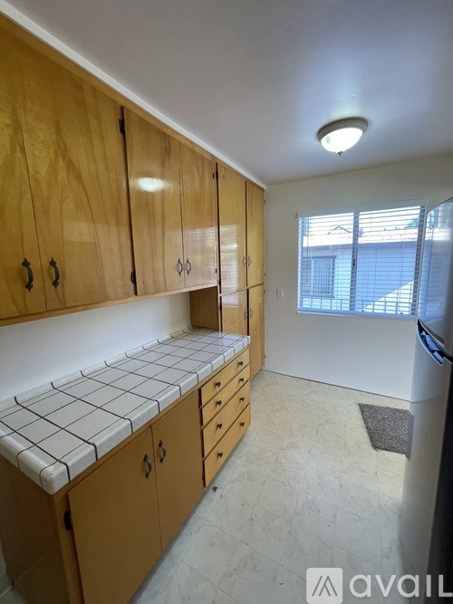 A kitchen with wooden cabinets and a white tile backsplash.