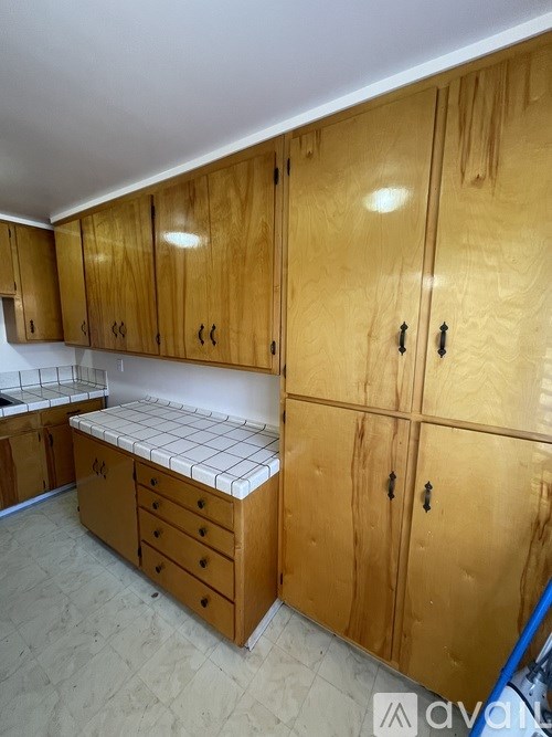A kitchen with wooden cabinets and a bench.