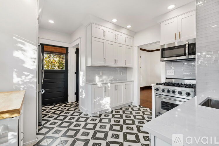 A kitchen with black and white tiles on the floor.