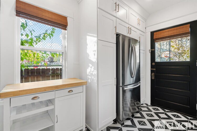 A kitchen with a black and white floor and white cabinets.
