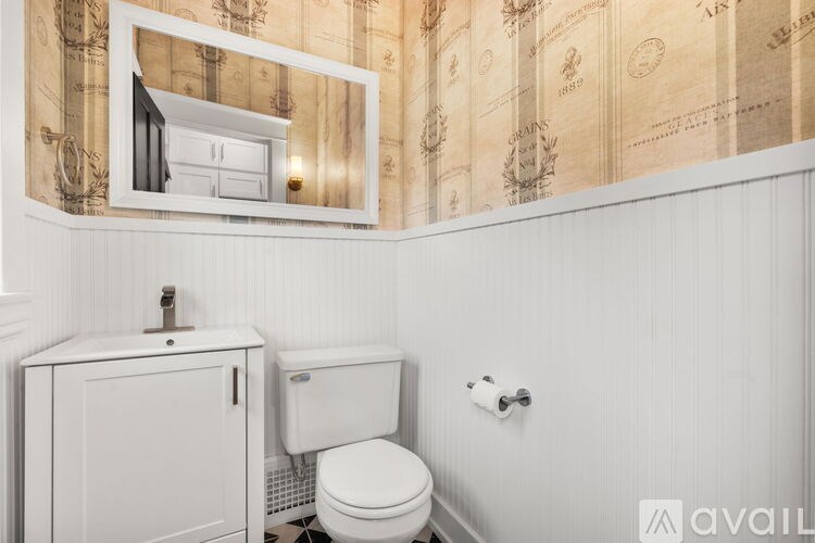 A white toilet sits next to a white cabinet in a bathroom.