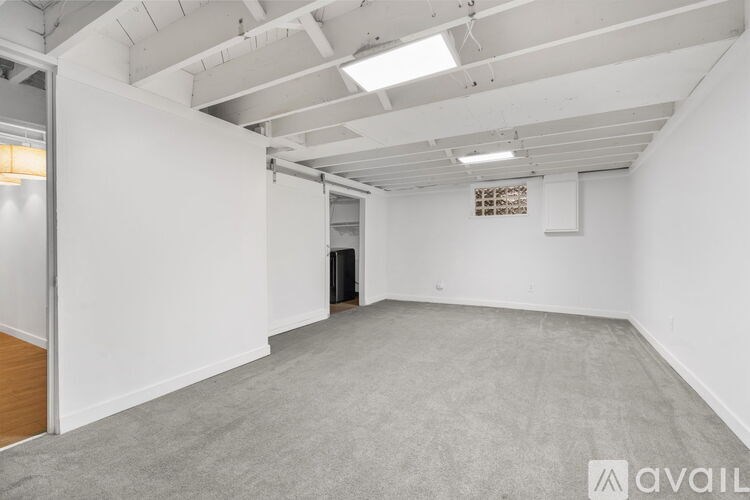 A large, empty room with a carpeted floor and white walls.