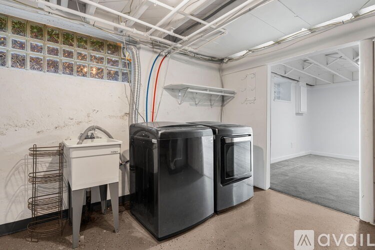 A kitchen appliance store with a white sink and two black refrigerators.