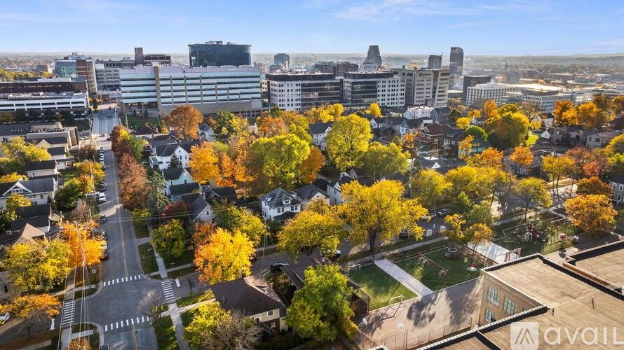 A cityscape with buildings and trees in autumn colors.