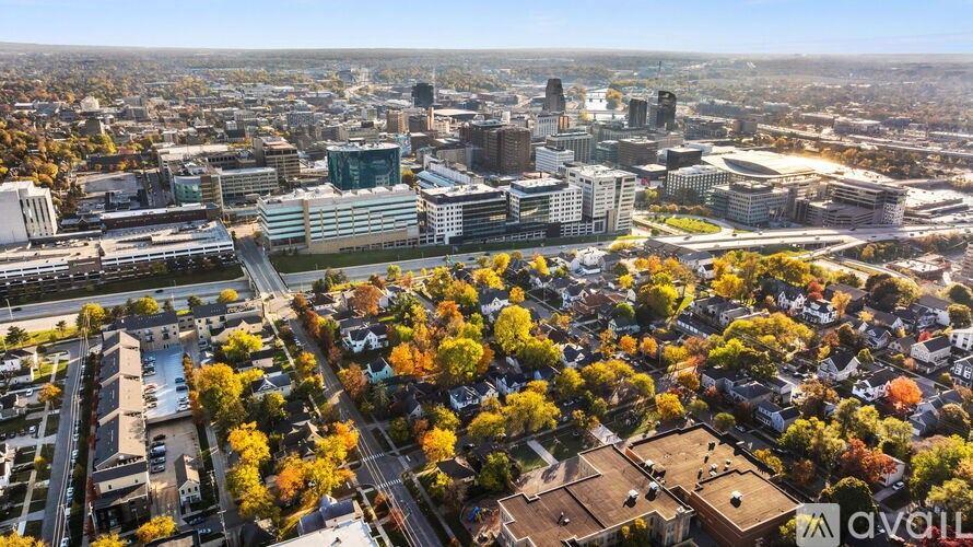 A cityscape with buildings and trees in autumn colors.