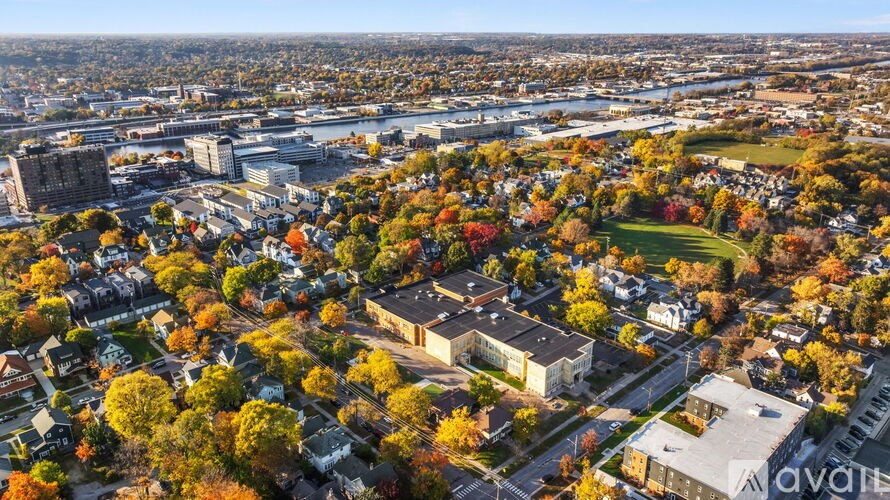 An aerial view of a city with buildings and trees in autumn colors.