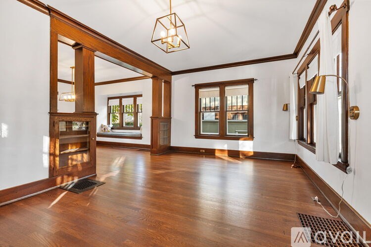 A spacious room with wooden floors and a large window.