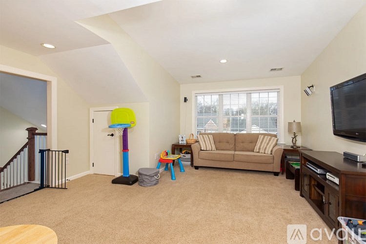 A living room with a couch, a television, and a play area for children.