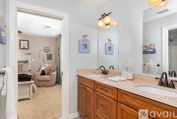 A bathroom with a double sink vanity and a mirror above it.