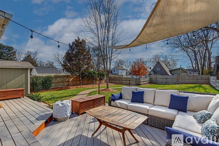 A wooden deck with a white sofa and a wooden table.