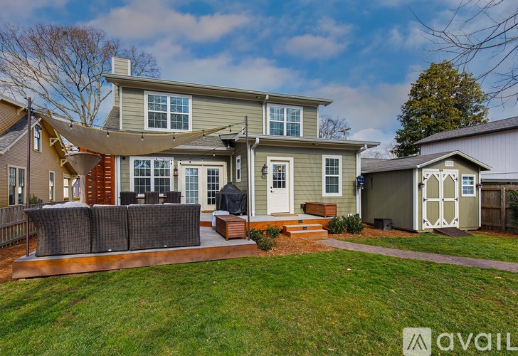 A house with a green lawn and a grey shed.