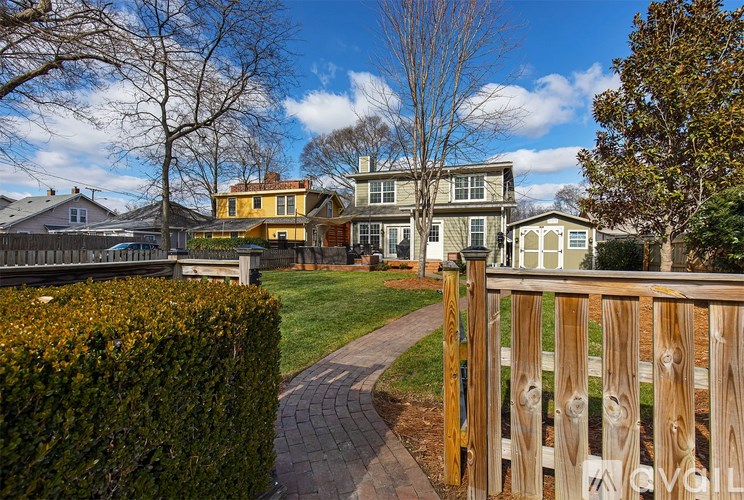 A house with a yellow fence in front of it.