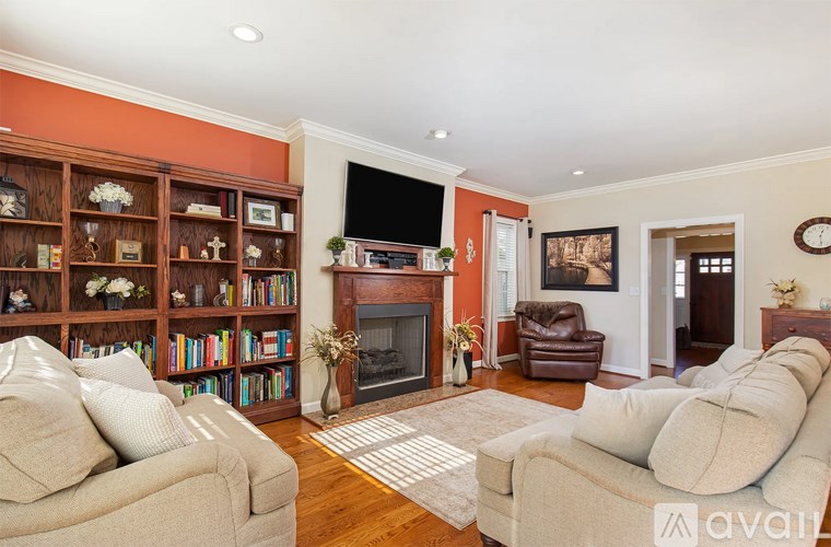 A living room with a fireplace, bookshelf, and a couch.