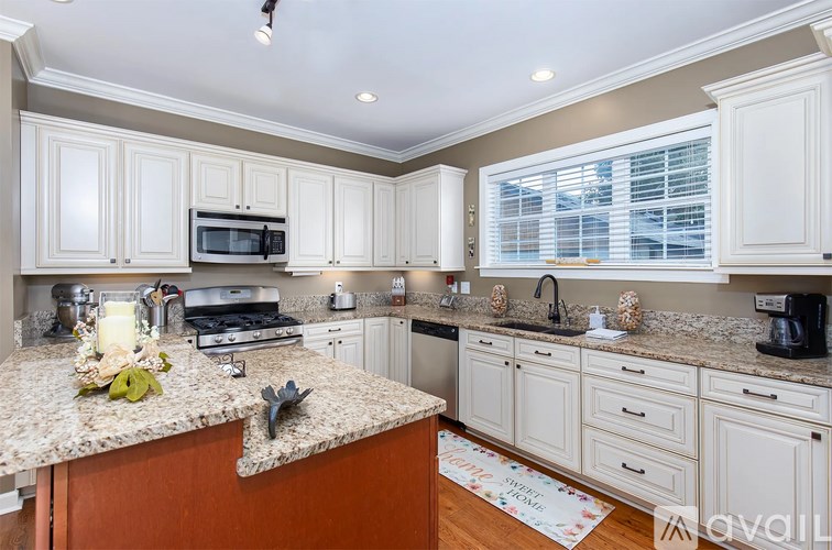 A kitchen with white cabinets and a granite countertop.