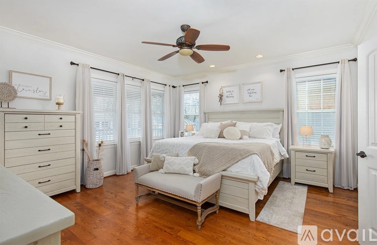 A bedroom with a bed, dresser, and chair.