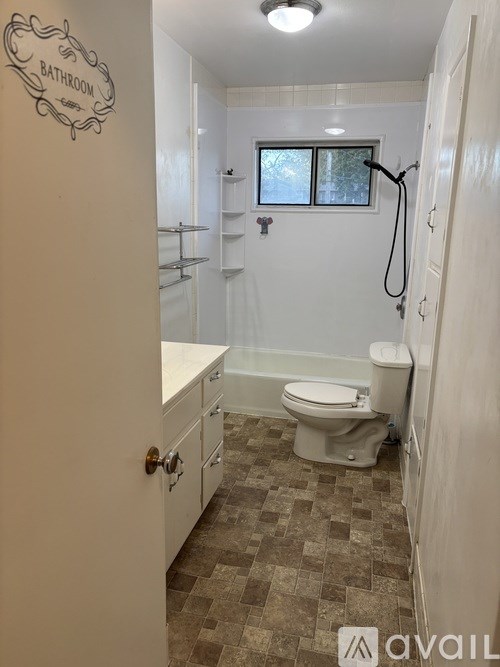 A bathroom with a toilet, sink, and shower.