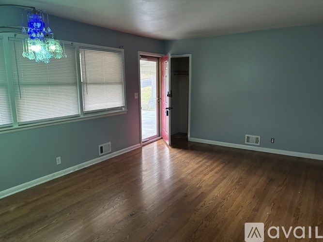 A room with wooden floors and a chandelier.