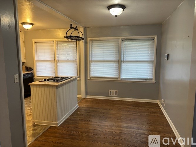 A kitchen with a wooden floor and white cabinets.