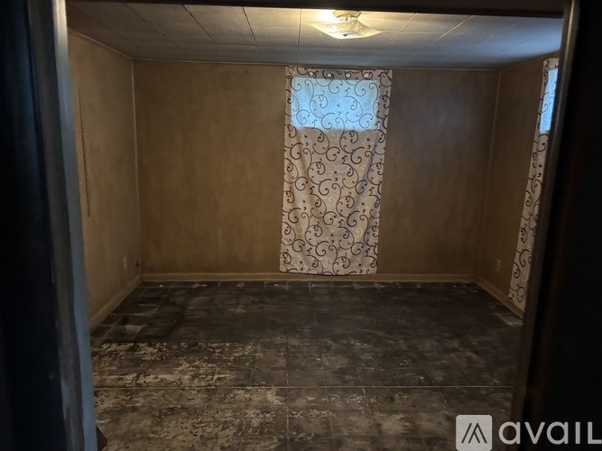 A room with a patterned curtain and a tiled floor.