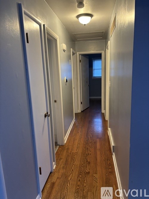 A long hallway with doors on both sides and a light on the ceiling.