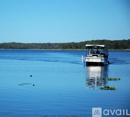 A boat is floating on a lake with a clear blue sky.
