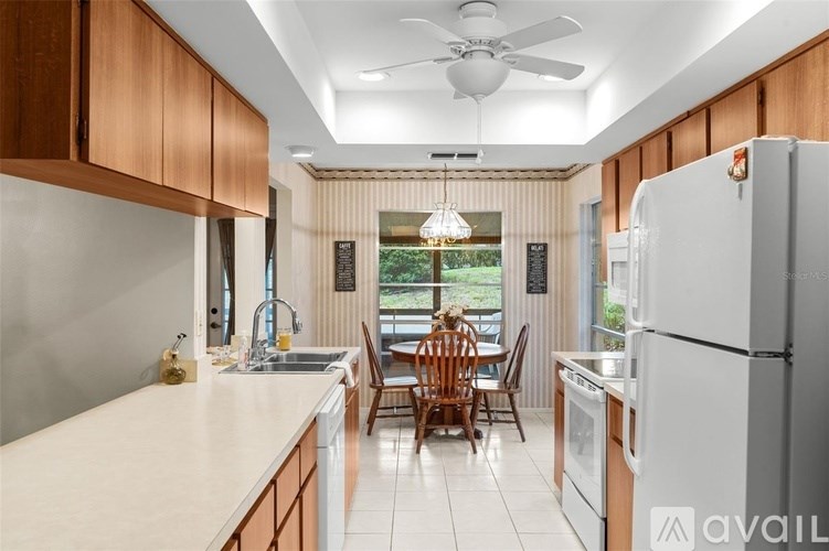 A kitchen with wooden cabinets and a white refrigerator.
