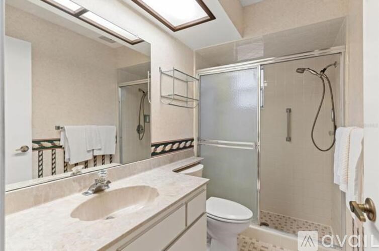 A bathroom with a sink, toilet, and shower.