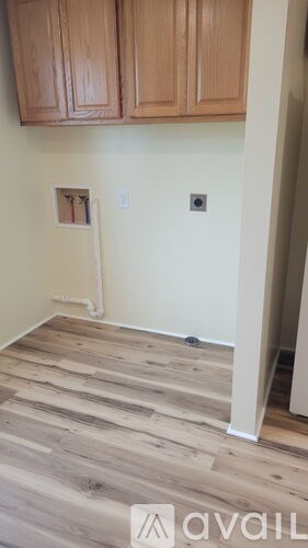 A room with wooden floors and cabinets above.