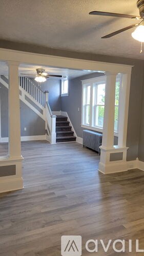 A spacious room with a staircase and a window.